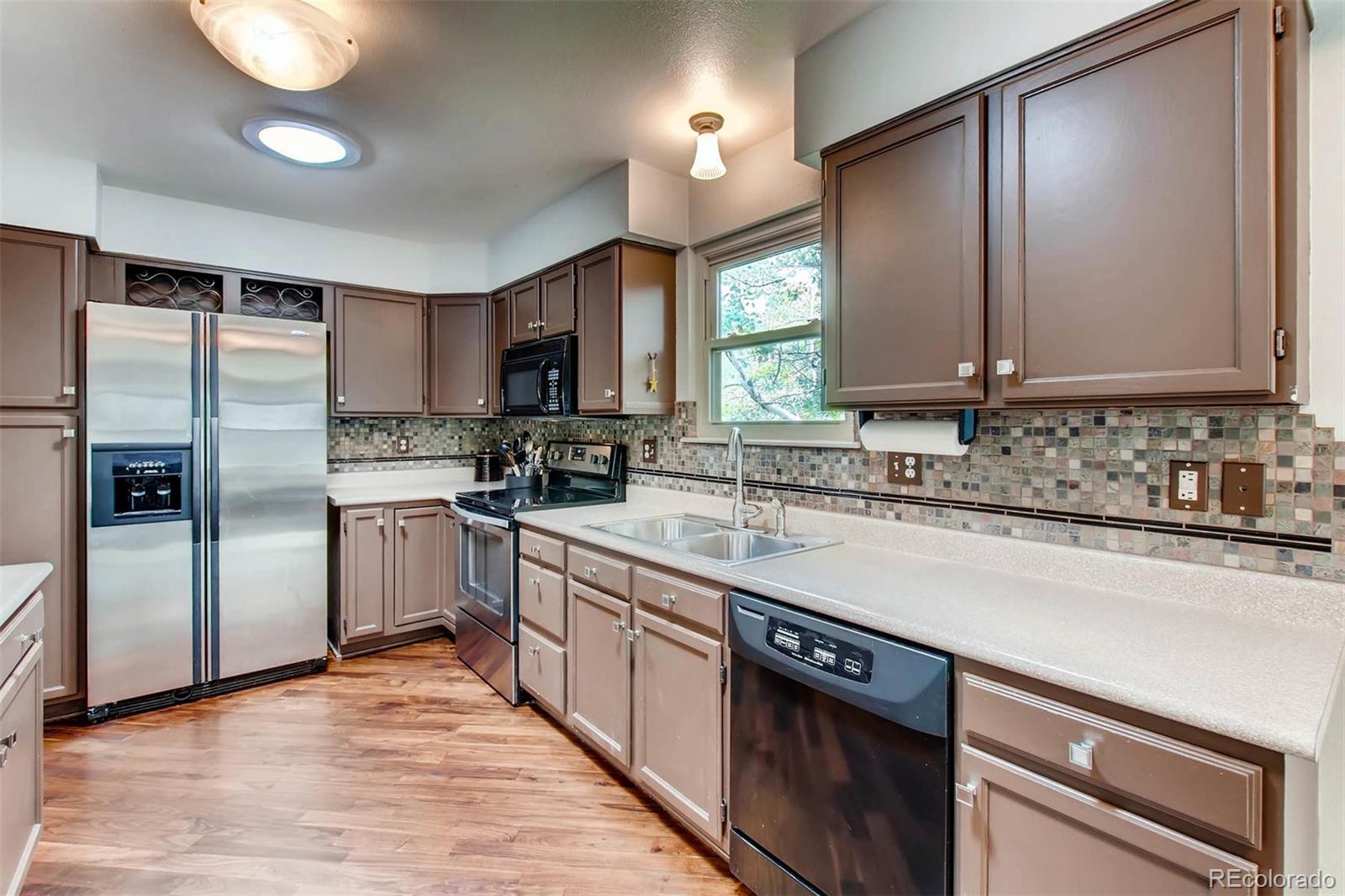 13360 Cherry Circle Thornton, CO 80241 - Photo 8 of 26 a kitchen with kitchen island granite countertop a sink appliances cabinets and counter space