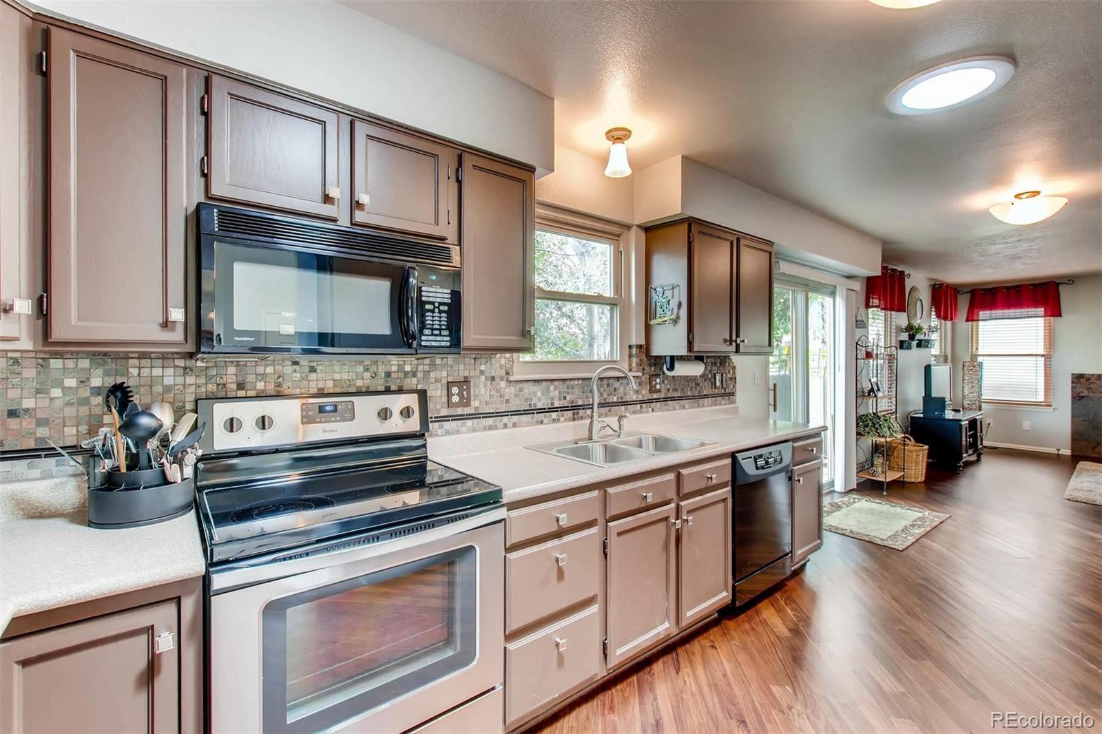 13360 Cherry Circle Thornton, CO 80241 - Photo 10 of 26 a kitchen with stainless steel appliances granite countertop a stove a sink and a microwave