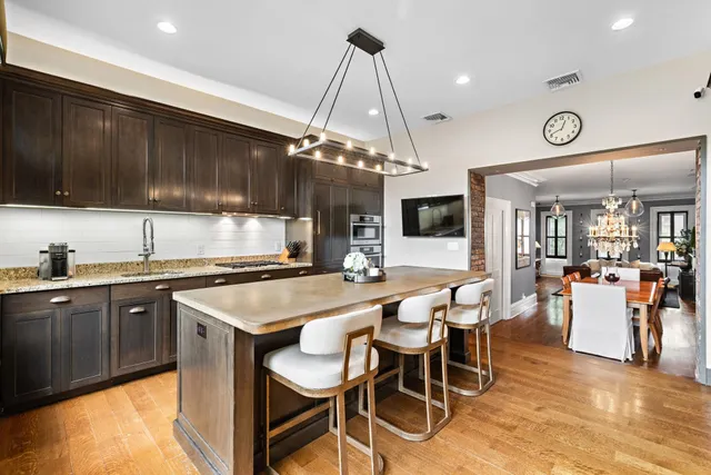 a kitchen with a dining table chairs sink and cabinets