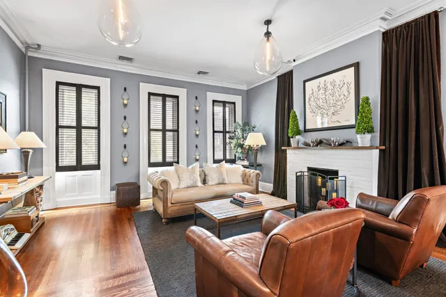 a living room with fireplace furniture and a large window