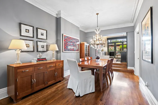 a dining room with furniture a chandelier and wooden floor