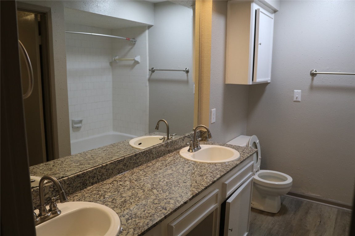 11530 Ridge Run Drive Houston, TX 77064 - Photo 21 of 38 a bathroom with a granite countertop toilet a sink and a mirror