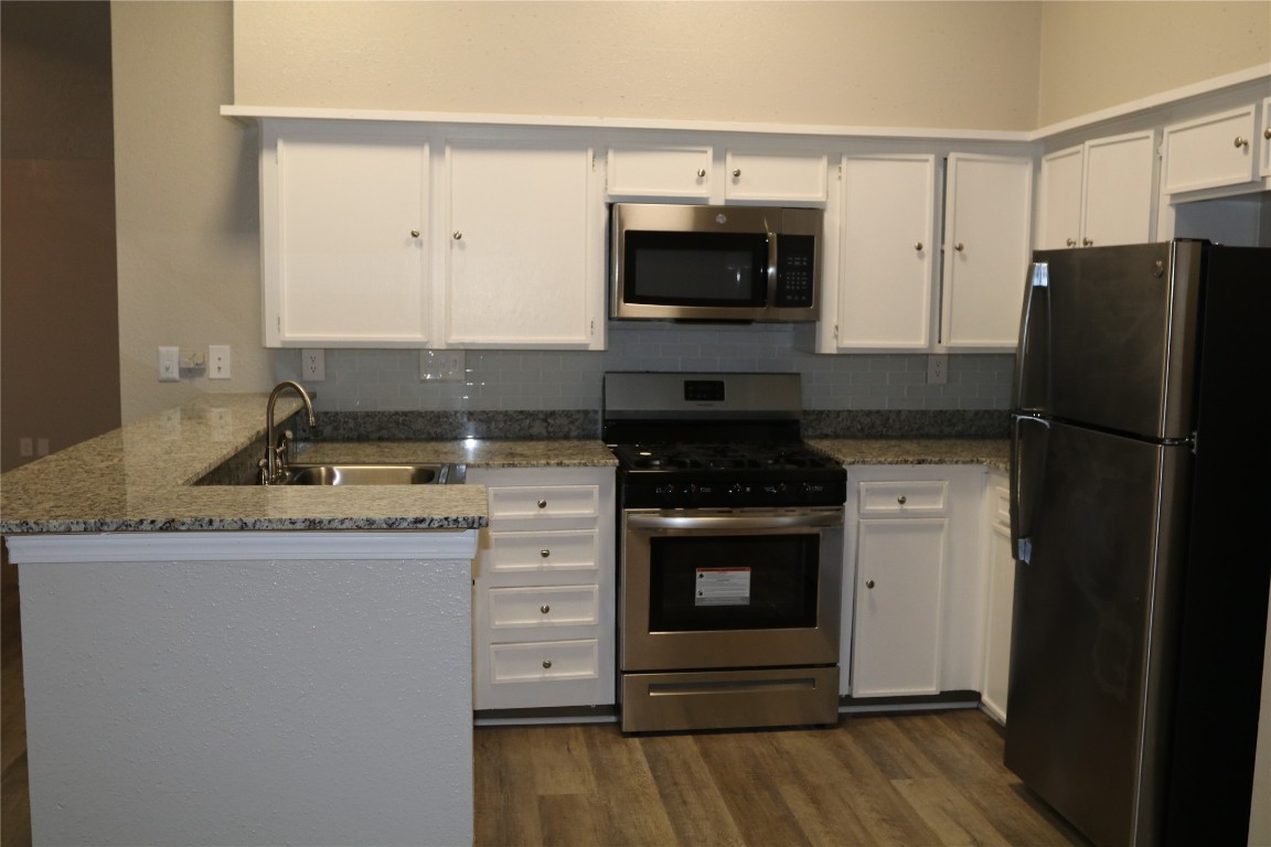 11530 Ridge Run Drive Houston, TX 77064 - Photo 7 of 38 a kitchen with granite countertop a stove and a refrigerator
