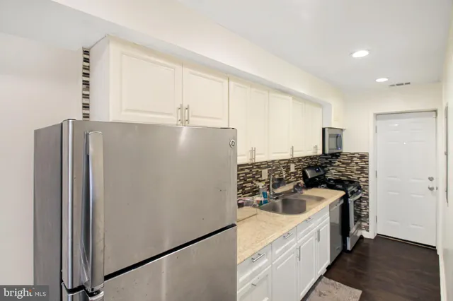 a kitchen with stainless steel appliances a refrigerator sink and stove