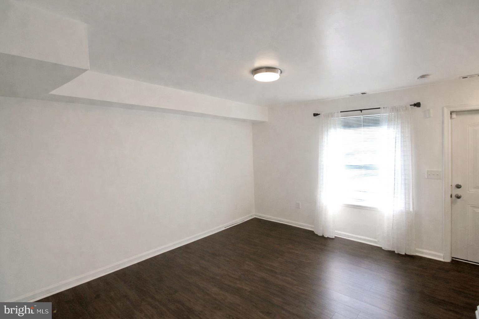 964 Mt Olivet Road Northeast Washington, DC 20002 - Photo 5 of 22 an empty room with wooden floor and windows