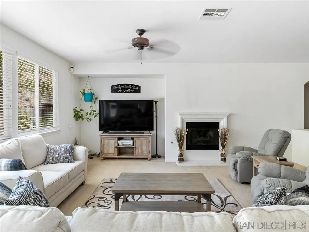 27874 Blackhawk Road Menifee, CA 92585 - Photo 4 of 21 a living room with furniture a flat screen tv and a fireplace
