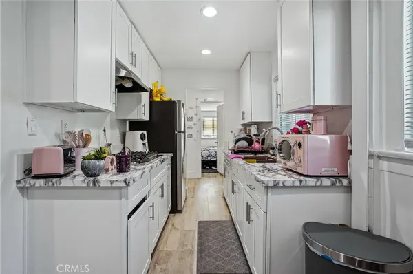 a kitchen with stainless steel appliances a sink dishwasher stove and white cabinets