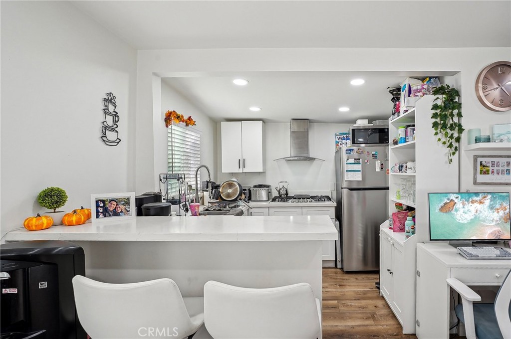 7251 Painter Avenue, Unit 7255 Whittier, CA 90602 - Photo 16 of 56 a kitchen with stainless steel appliances kitchen island granite countertop a sink and a refrigerator