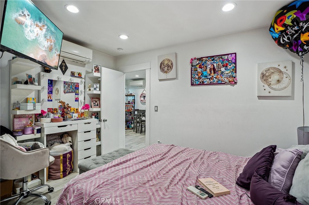 7251 Painter Avenue, Unit 7255 Whittier, CA 90602 - Photo 24 of 56 a bedroom with a bed and a bookshelf with wooden floor