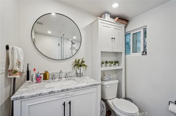 a bathroom with a sink mirror and toilet