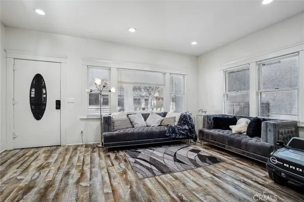 a living room with furniture a dining table a lamp and a chandelier