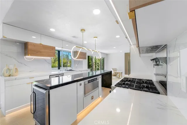 a kitchen with stainless steel appliances a sink stove and cabinets