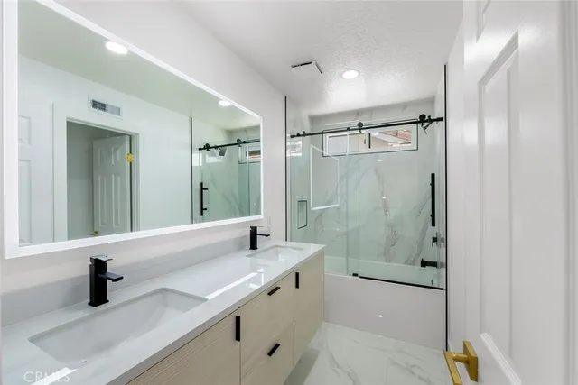 a bathroom with a granite countertop sink mirror and shower