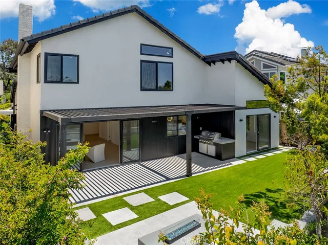 a view of house with backyard and furniture
