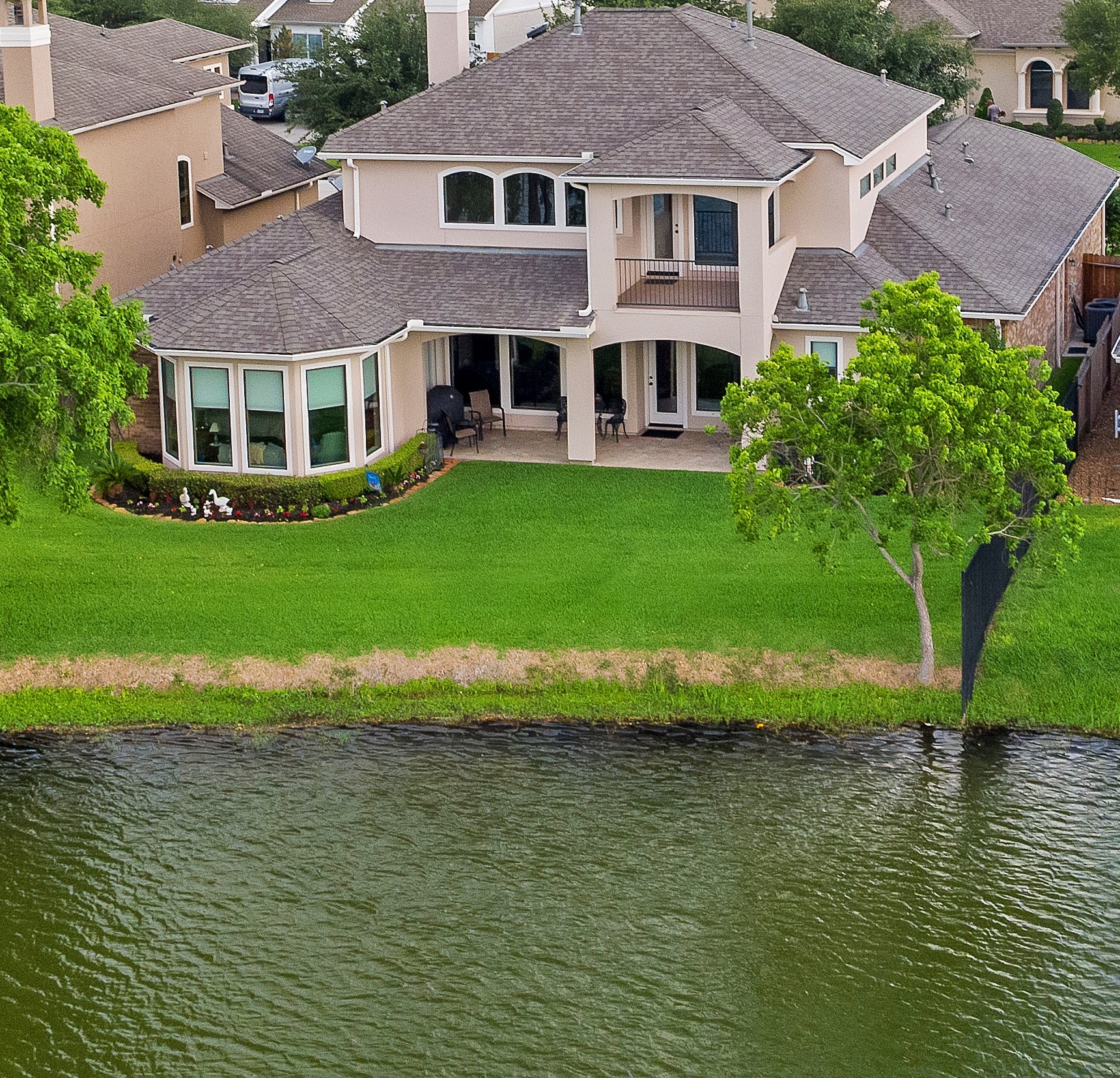 6119 Lofty Lane Spring, TX 77379 - Photo 5 of 40 This home offers a breathtaking lakefront view, surrounded by lush mature landscaping. The setting offers a well-maintained neighborhood with similar upscale homes, providing a serene and inviting environment.