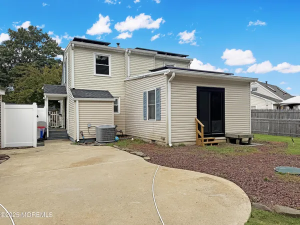 a view of a backyard with table and chairs potted plants and a palm tree