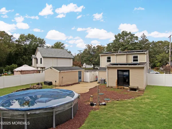 an aerial view of a house with swimming pool and outdoor seating