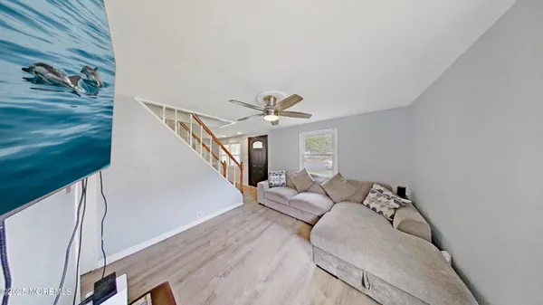 a living room with furniture and a ceiling fan