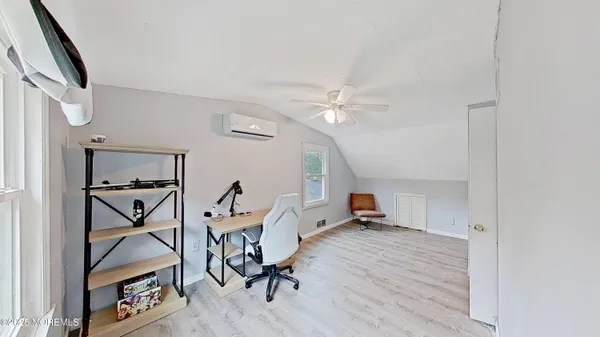 a bedroom with a bed and a flat tv screen on the dresser