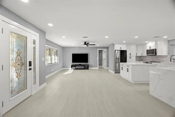 a view of kitchen with a sink a refrigerator and a living room