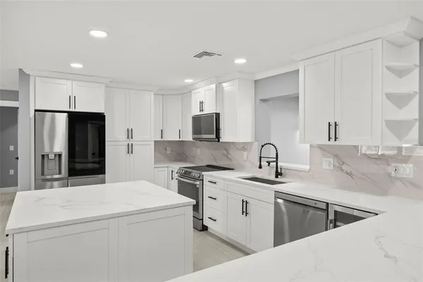 a kitchen that has a sink and a stove in it