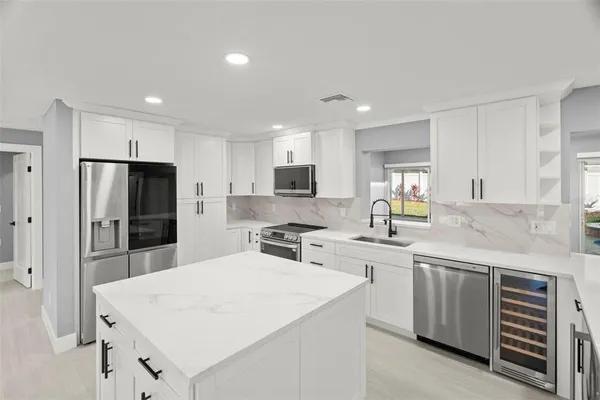 a kitchen with a sink a counter top stainless steel appliances and cabinets
