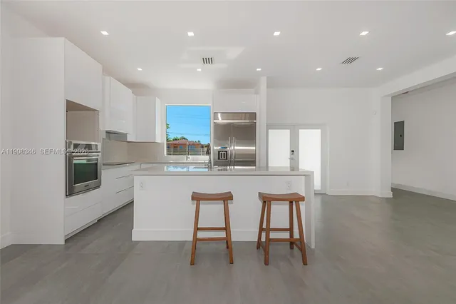 a kitchen with a sink and chairs