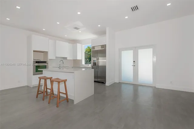 a kitchen with white cabinets and stainless steel appliances