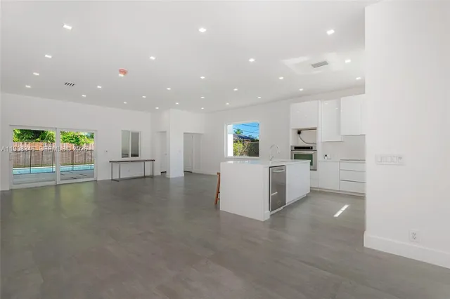 a view of kitchen with kitchen island and stainless steel appliances