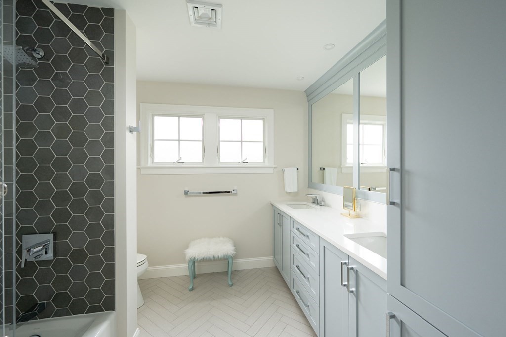 155 Black Rock Drive, Unit 155 Hingham, MA 02043 - Photo 27 of 42 a spacious bathroom with a double vanity sink a toilet and a mirror