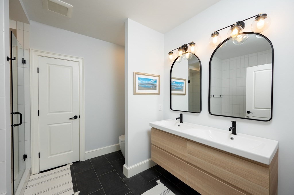 155 Black Rock Drive, Unit 155 Hingham, MA 02043 - Photo 29 of 42 a bathroom with a double vanity sink and a mirror