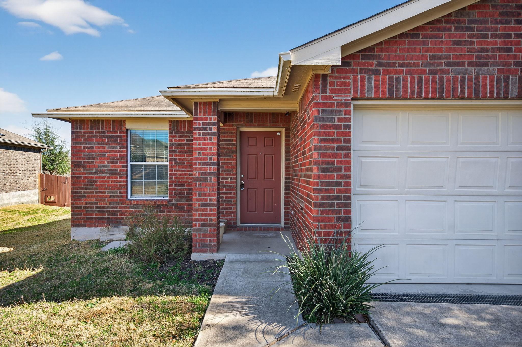 13629 Coomer Path Pflugerville, TX 78660 - Photo 2 of 30 Entrance to property featuring an attached garage, brick siding, a yard, and a shingled roof