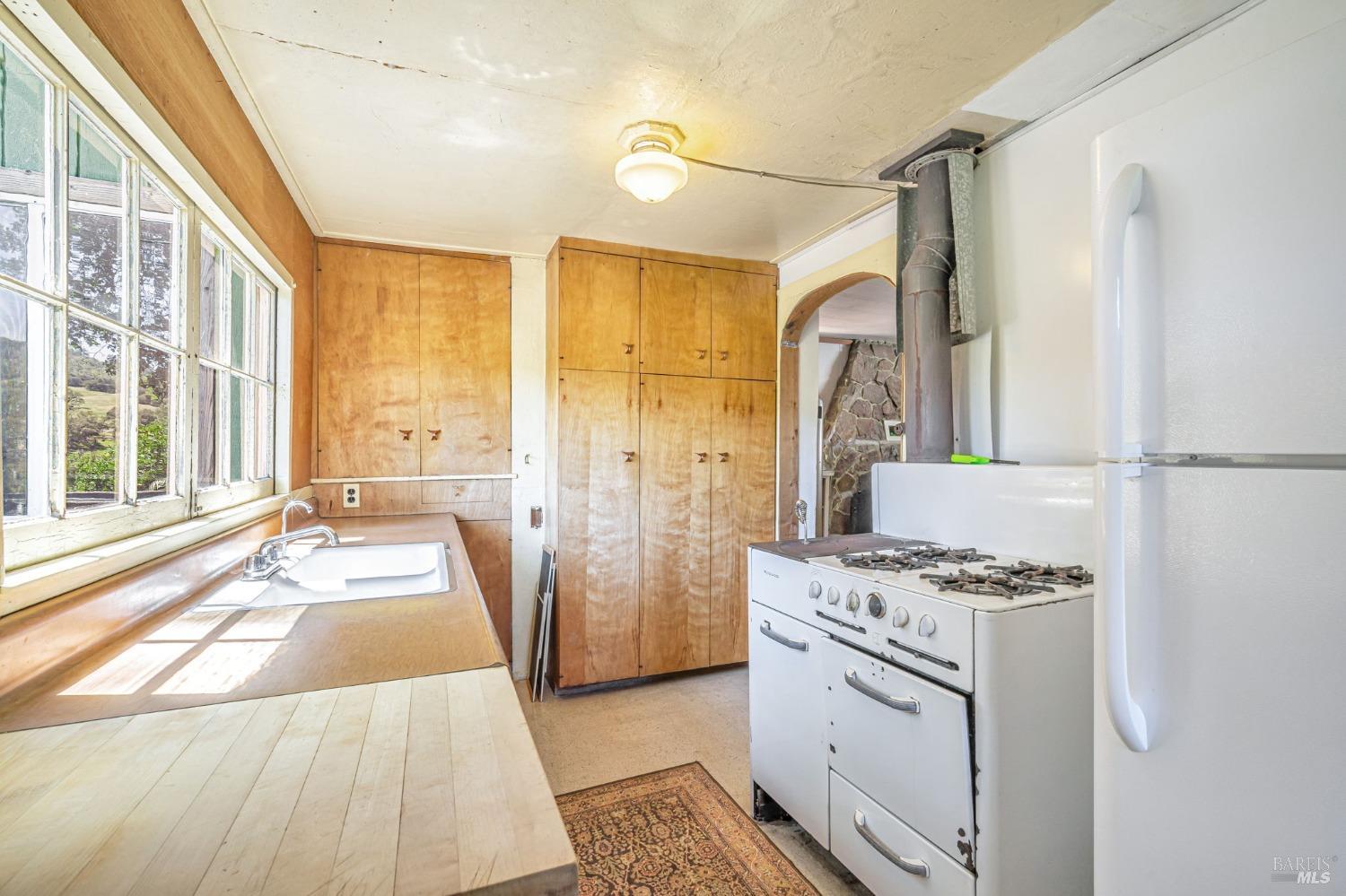 1561 South Fitch Mountain Road Healdsburg, CA 95448 - Photo 18 of 44 a kitchen with granite countertop a sink stove and refrigerator