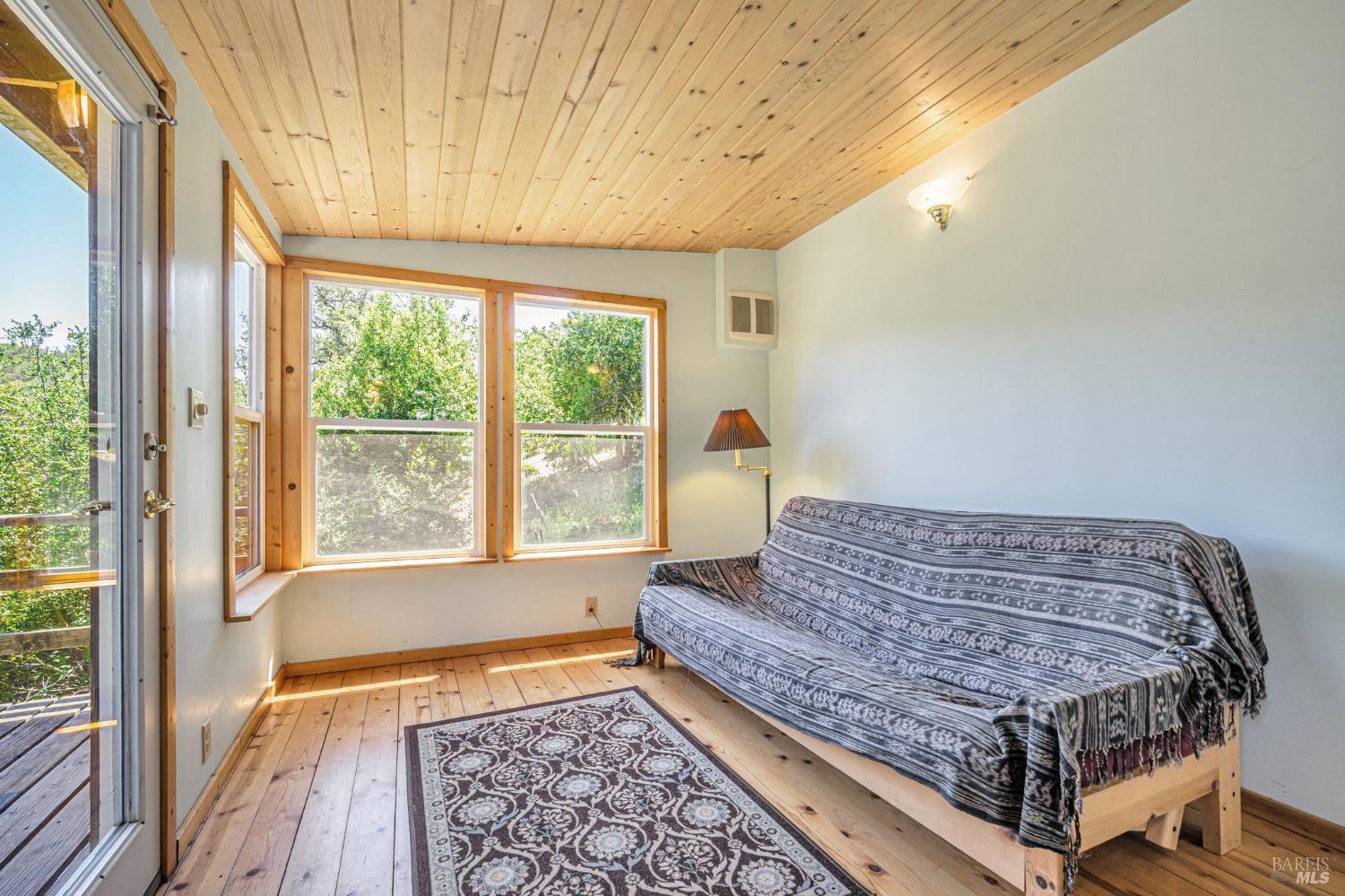 1561 South Fitch Mountain Road Healdsburg, CA 95448 - Photo 10 of 44 a bedroom with a bed and wooden floor