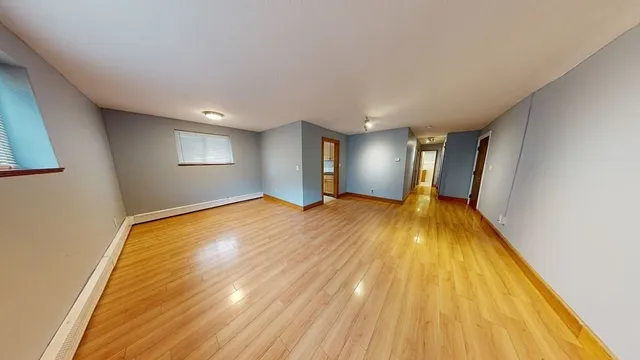 a view of a room with wooden floor and window