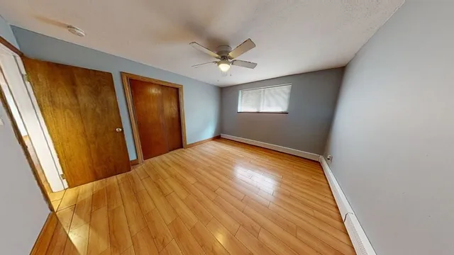 a view of empty room with window and ceiling fan