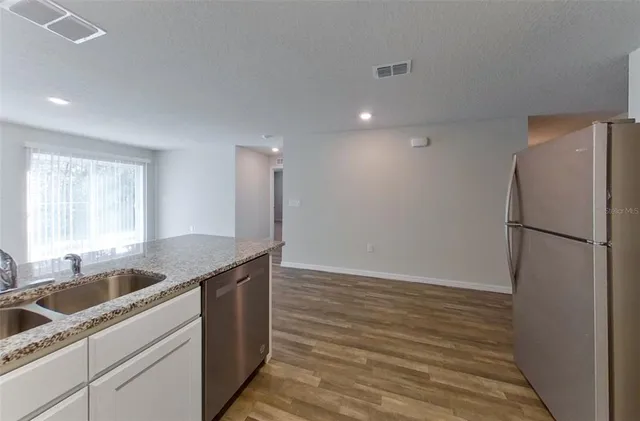 a kitchen that has a sink a refrigerator and window
