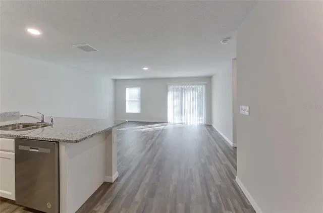 a view of a kitchen cabinets a sink and wooden floor