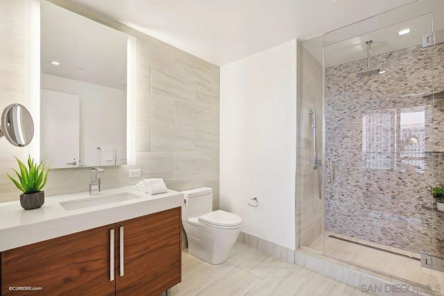 a bathroom with a sink a toilet and shower