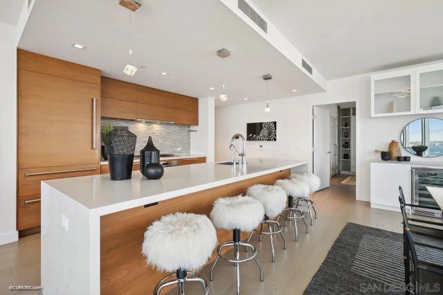 a large kitchen with kitchen island a large counter top space a sink stainless steel appliances and cabinets