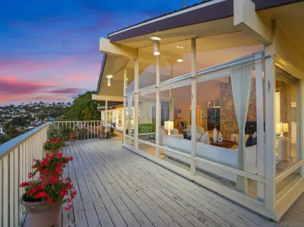 a view of a balcony with wooden floor and potted plants