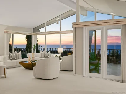 a living room with furniture and floor to ceiling windows