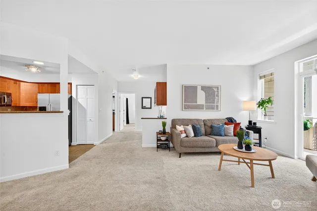 a living room with furniture and a dining table with kitchen view