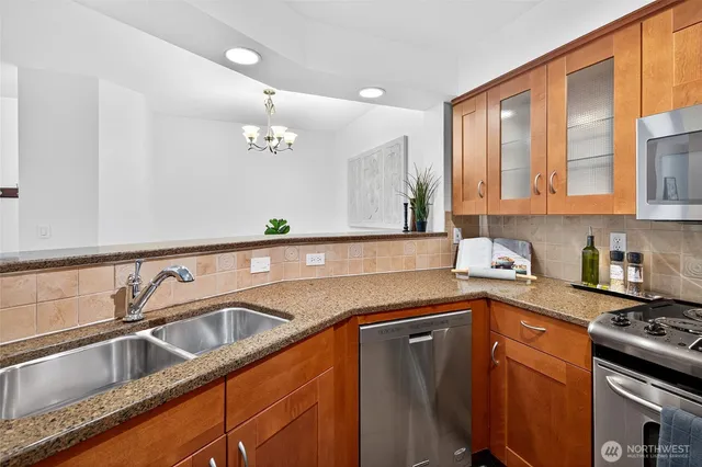 a kitchen with stainless steel appliances granite countertop a sink stove and cabinets