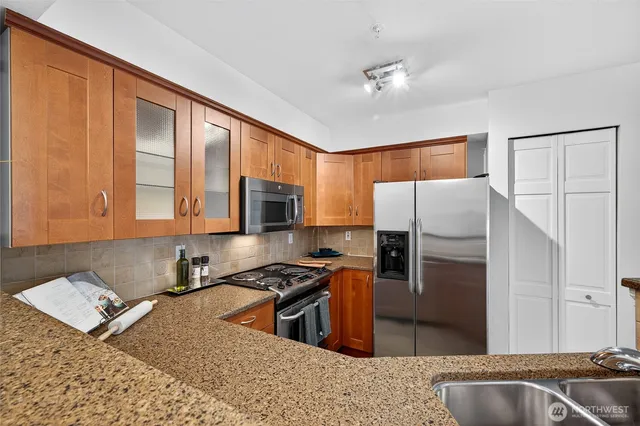 a kitchen with stainless steel appliances granite countertop a refrigerator stove and sink