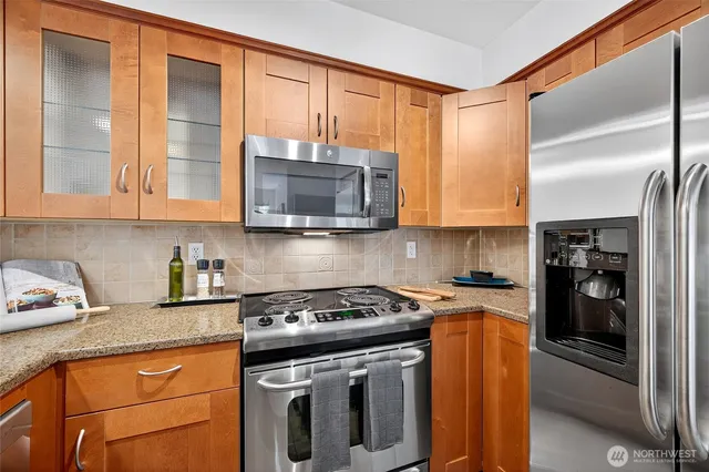 a kitchen with stainless steel appliances granite countertop a stove a refrigerator and a microwave