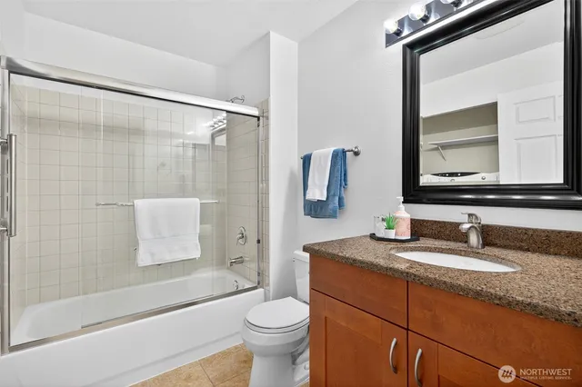 a bathroom with a granite countertop sink toilet and shower
