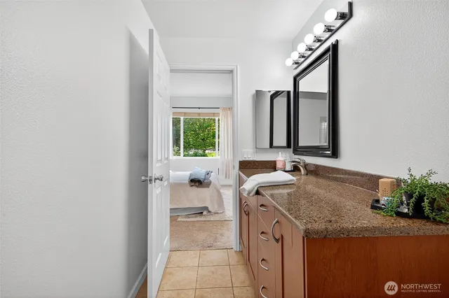 a bathroom with a granite countertop sink and a mirror