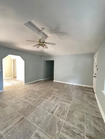 a view of a livingroom with a ceiling fan and window
