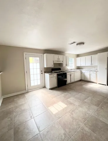 a view of a kitchen with a stove top oven and cabinets